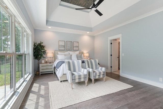 bedroom featuring access to exterior, a towering ceiling, dark hardwood / wood-style flooring, a tray ceiling, and ceiling fan