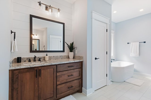 bathroom featuring a bathing tub, vanity, and tile patterned floors