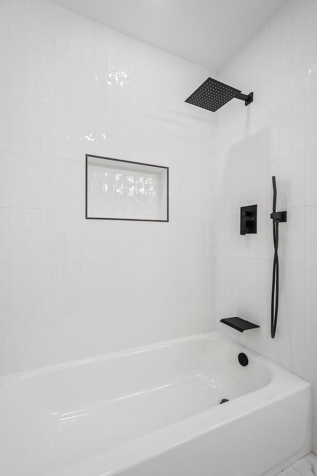 bathroom featuring tiled shower / bath