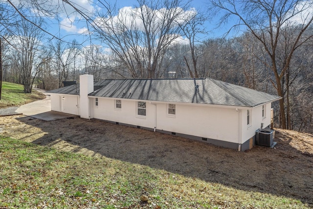 view of side of home with central AC and a yard