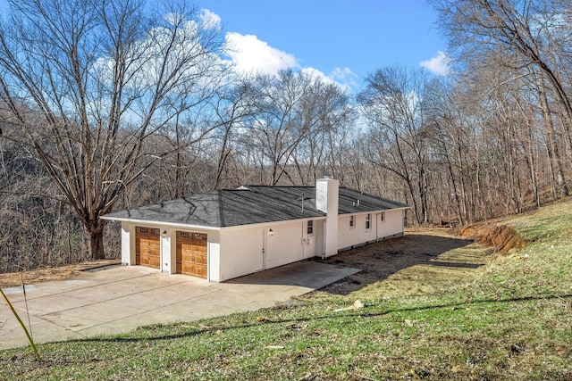 view of side of home with a garage and a lawn