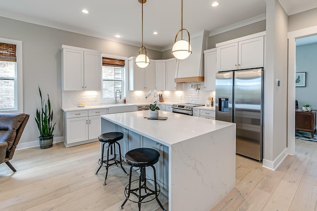 kitchen with stainless steel appliances, a kitchen island, and white cabinetry