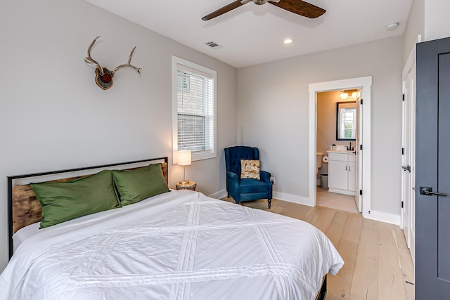 bedroom with multiple windows, connected bathroom, light hardwood / wood-style floors, and ceiling fan