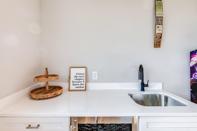 kitchen featuring white cabinetry, beverage cooler, and sink