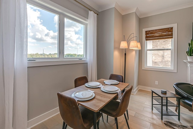 dining room featuring a fireplace, light hardwood / wood-style floors, and ornamental molding