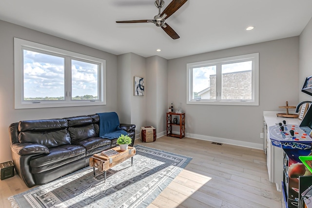 living room with ceiling fan and light hardwood / wood-style floors