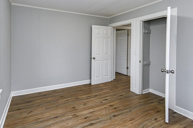 unfurnished bedroom featuring dark hardwood / wood-style floors, ornamental molding, and a closet