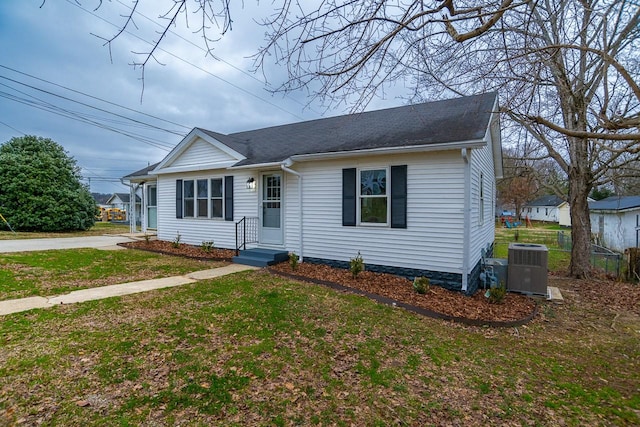 view of front of house with central AC unit and a front lawn