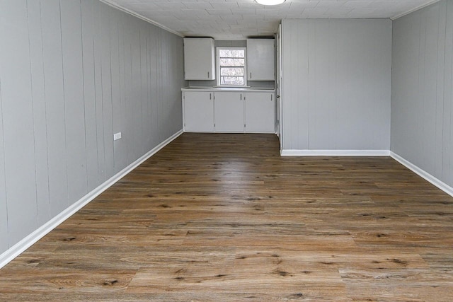 spare room featuring hardwood / wood-style floors, crown molding, and wooden walls