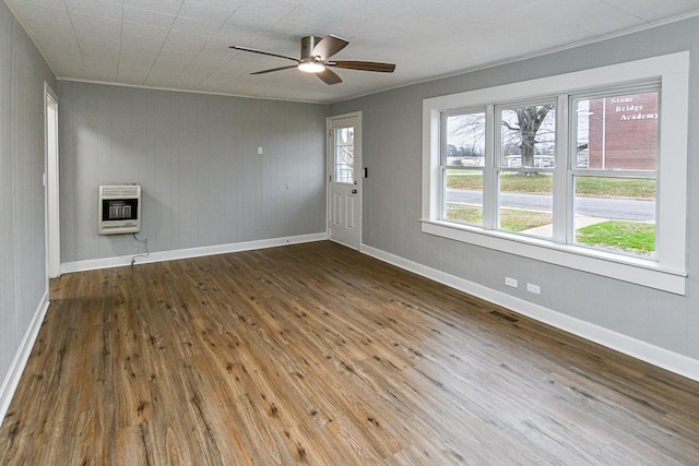 unfurnished room featuring hardwood / wood-style floors, heating unit, ceiling fan, and ornamental molding