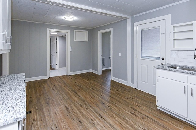 interior space featuring dark hardwood / wood-style flooring, crown molding, sink, and built in features