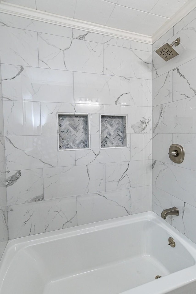 bathroom featuring crown molding and tiled shower / bath