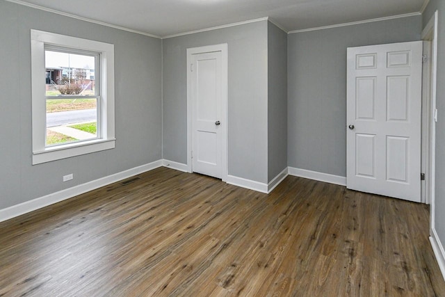 unfurnished bedroom with dark hardwood / wood-style floors and ornamental molding