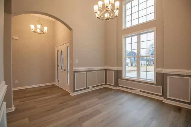 entrance foyer featuring a notable chandelier, hardwood / wood-style floors, and plenty of natural light