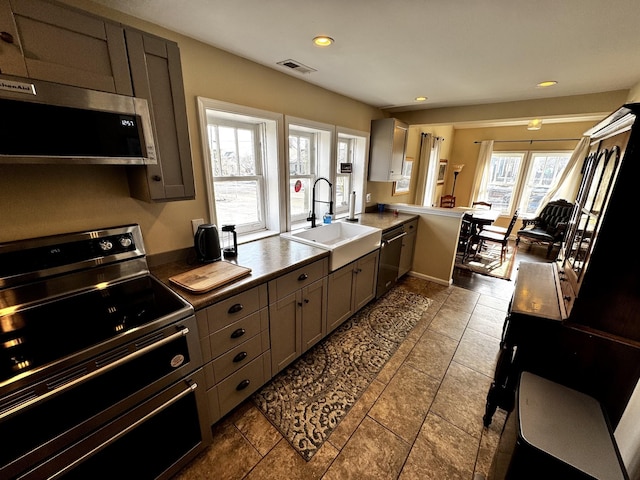 kitchen featuring appliances with stainless steel finishes, kitchen peninsula, and sink