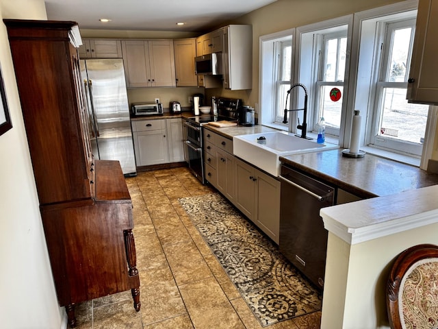 kitchen with sink, stainless steel appliances, a healthy amount of sunlight, and gray cabinetry