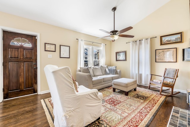 living area with dark wood-style flooring, a ceiling fan, and baseboards