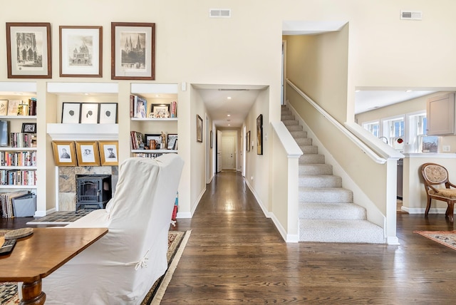 foyer entrance featuring dark wood-style floors, baseboards, stairs, and visible vents