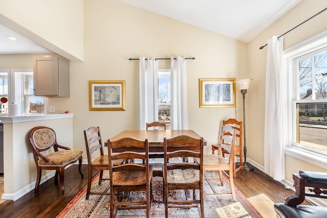 dining area with lofted ceiling, baseboards, and wood finished floors