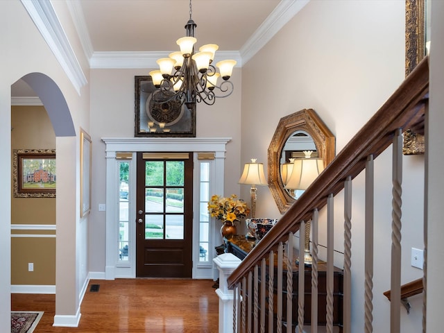 foyer featuring ornamental molding, an inviting chandelier, and hardwood / wood-style flooring