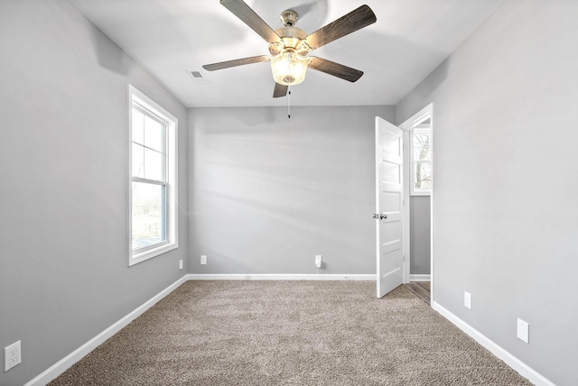 carpeted empty room with ceiling fan and a healthy amount of sunlight