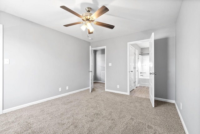 unfurnished bedroom with ensuite bathroom, ceiling fan, and light colored carpet