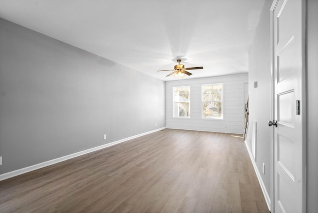 empty room with dark hardwood / wood-style flooring and ceiling fan