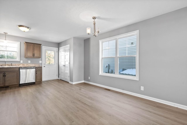 kitchen featuring light hardwood / wood-style floors, an inviting chandelier, dishwasher, and pendant lighting