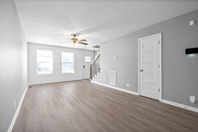 unfurnished living room featuring ceiling fan and dark hardwood / wood-style floors