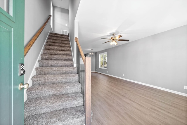 stairway with ceiling fan and hardwood / wood-style floors