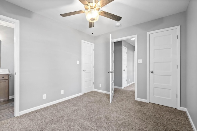 unfurnished bedroom featuring ceiling fan, ensuite bathroom, and carpet