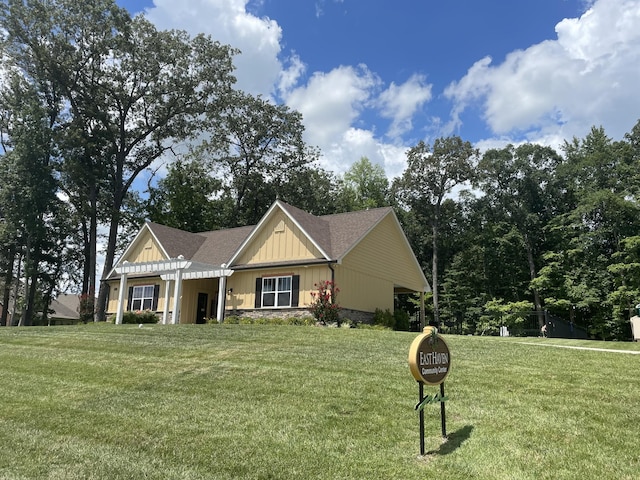 view of front of house with a front yard and a pergola