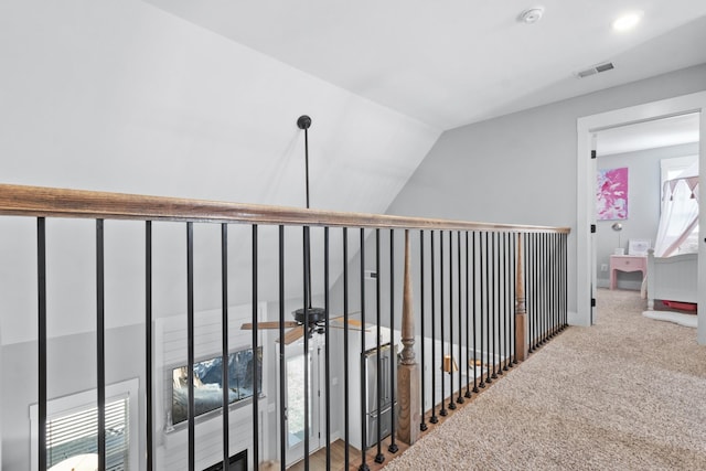 corridor with plenty of natural light, lofted ceiling, and carpet flooring