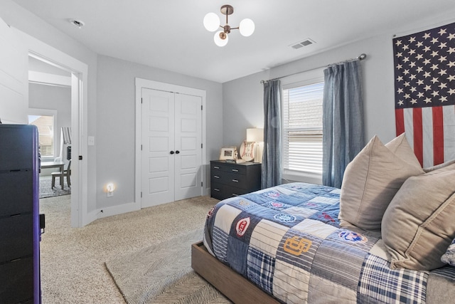 bedroom featuring an inviting chandelier, a closet, and carpet flooring