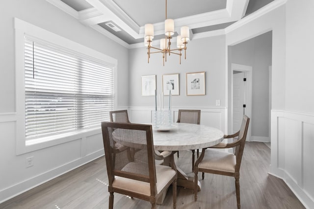 dining space featuring ornamental molding, a notable chandelier, and hardwood / wood-style flooring