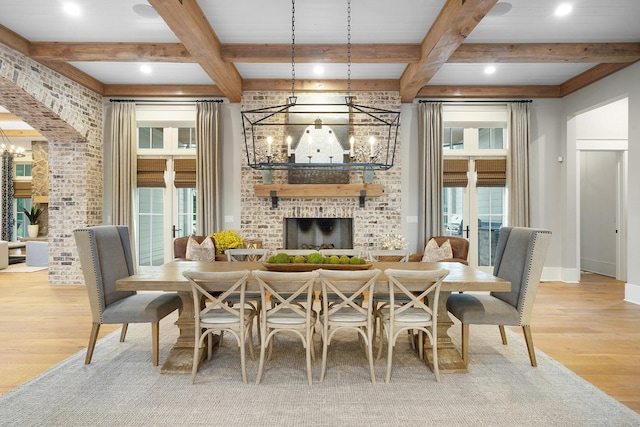 dining area with beam ceiling, a healthy amount of sunlight, and a fireplace