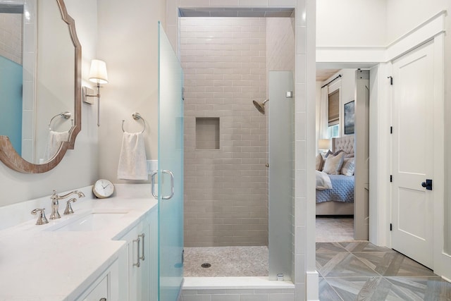 bathroom featuring a shower with door and vanity