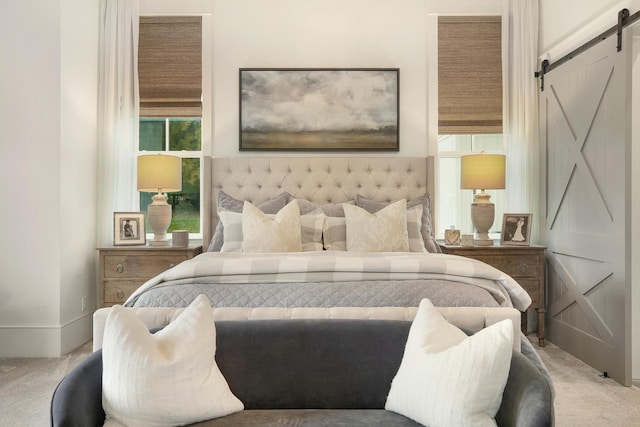 carpeted bedroom featuring a barn door and multiple windows