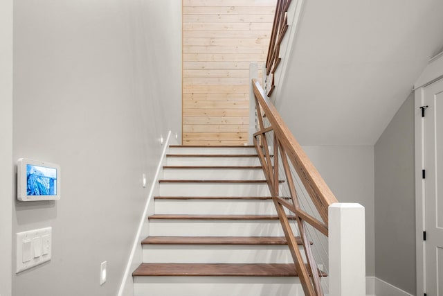 stairs featuring wood walls