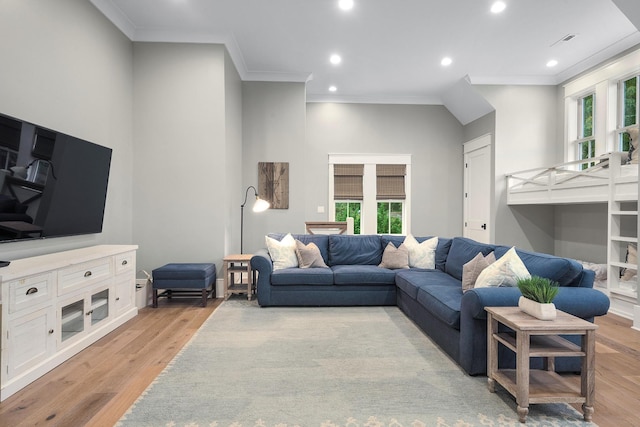 living room featuring light wood-type flooring and crown molding