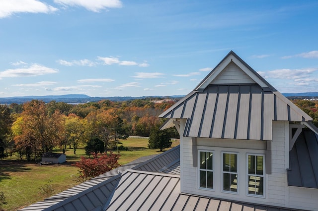 view of side of property with a mountain view and a lawn