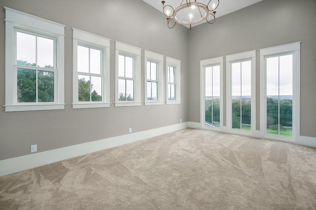 unfurnished sunroom featuring a healthy amount of sunlight and a chandelier