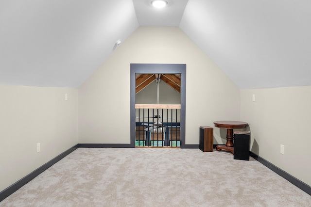 bonus room with vaulted ceiling and carpet