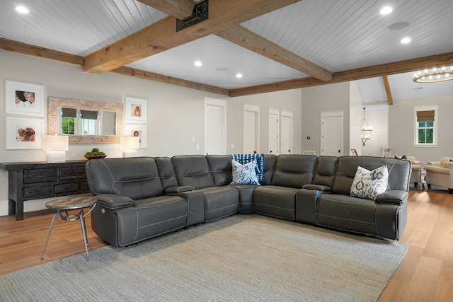 living room featuring a healthy amount of sunlight, light hardwood / wood-style flooring, and beamed ceiling