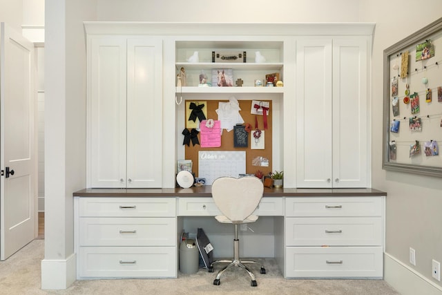 carpeted office featuring built in desk