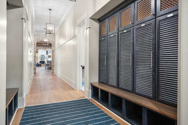 mudroom featuring hardwood / wood-style flooring, a notable chandelier, and ornamental molding