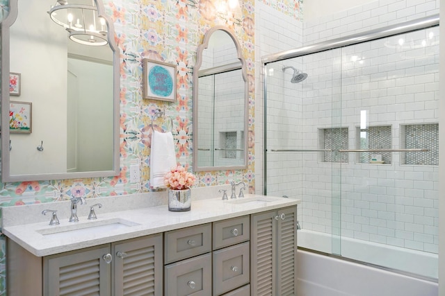 bathroom featuring an inviting chandelier, bath / shower combo with glass door, and vanity