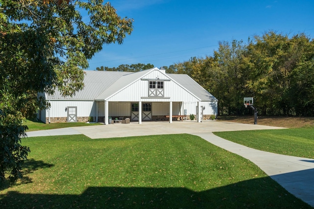 back of property featuring an outdoor structure and a lawn