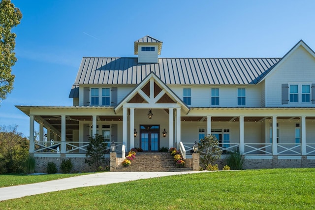 view of front of home featuring a porch, french doors, and a front lawn