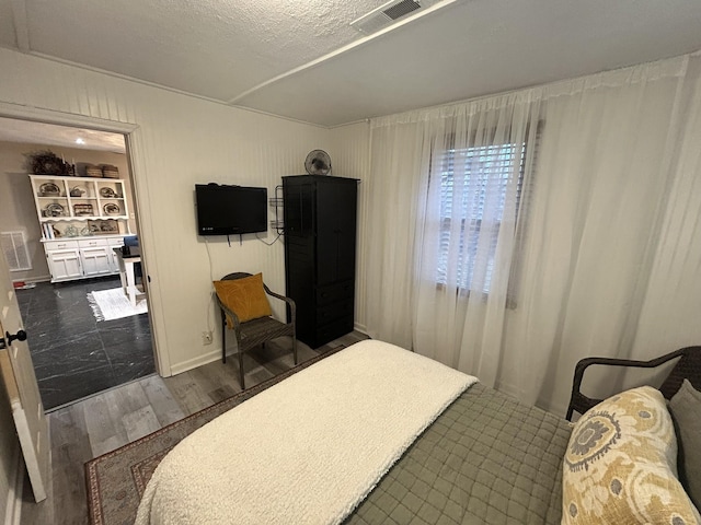 bedroom featuring dark hardwood / wood-style flooring and a textured ceiling